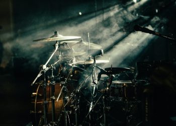 a drum set up in front of a stage light