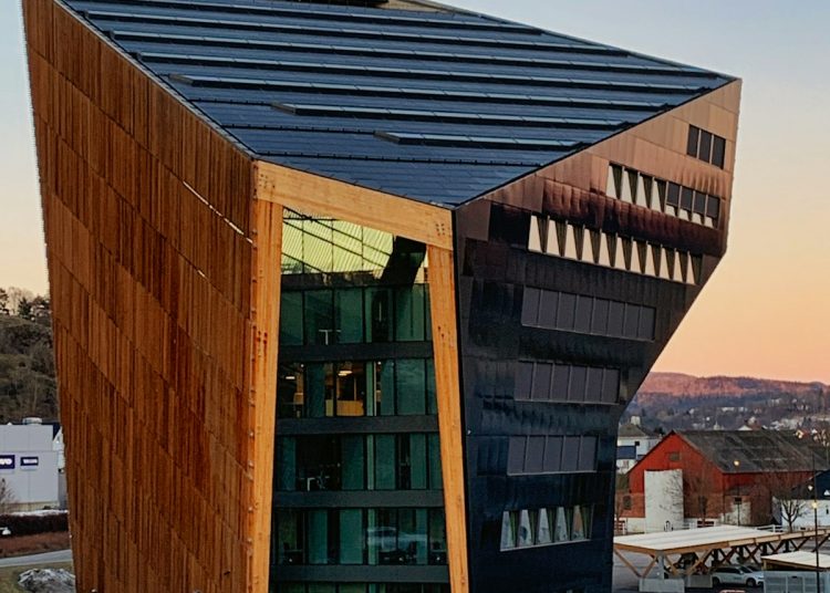 a building with a triangular roof and a blue fence around it
